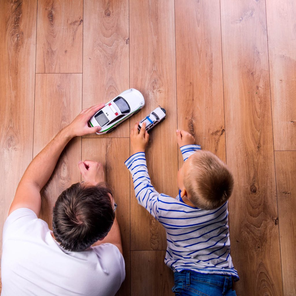 Father with kid playing with toycar | Lake Forest Flooring