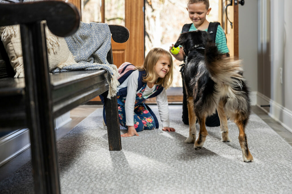 Kids playing with dog on carpet floors | Lake Forest Flooring